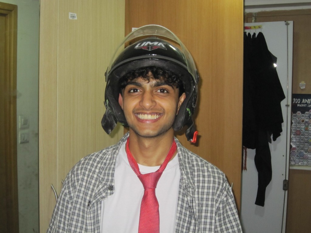 Denel in a helmet, plaid shirt, and red tie