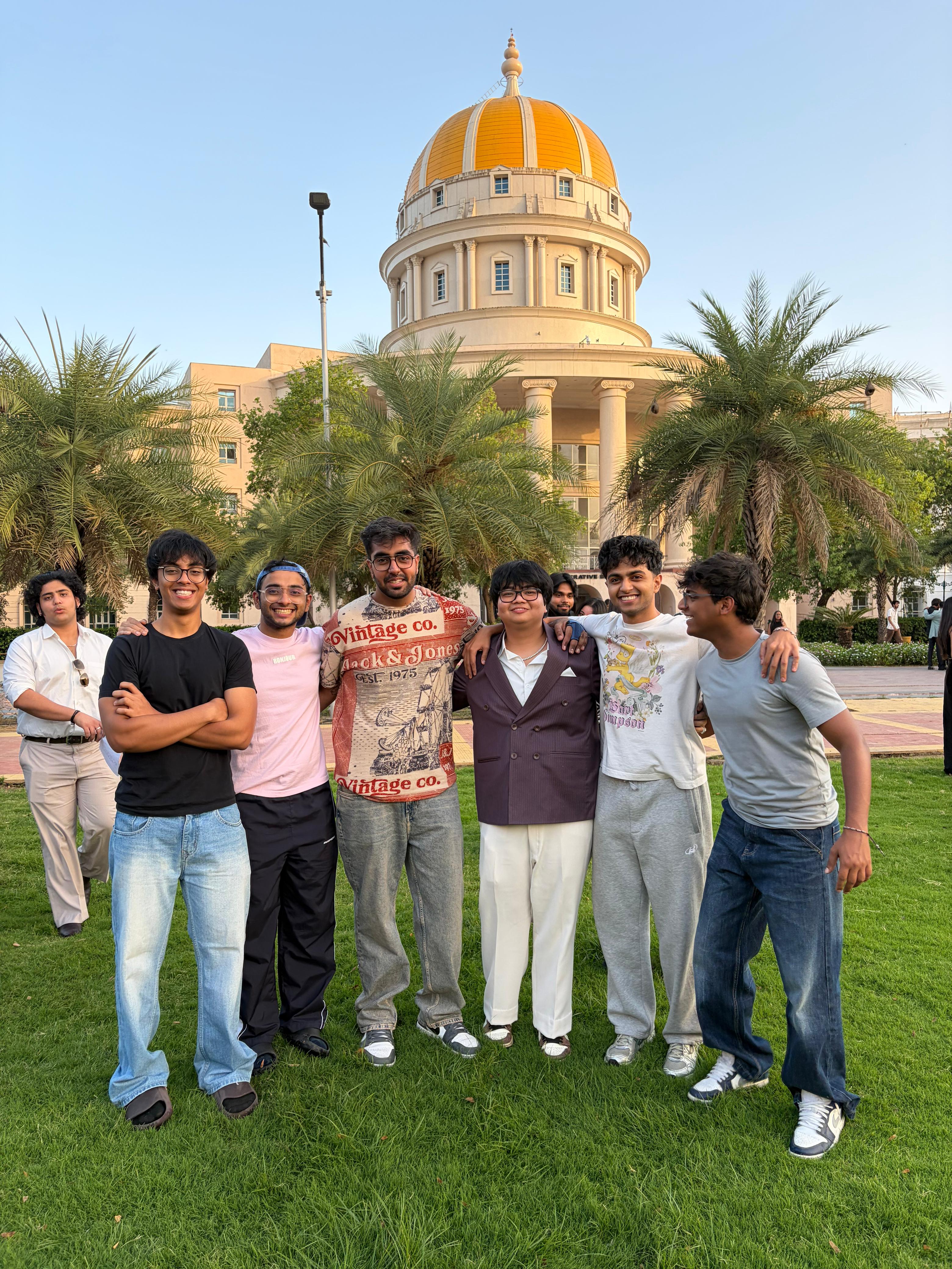 Friends standing together on a lawn in front of a gold-domed building