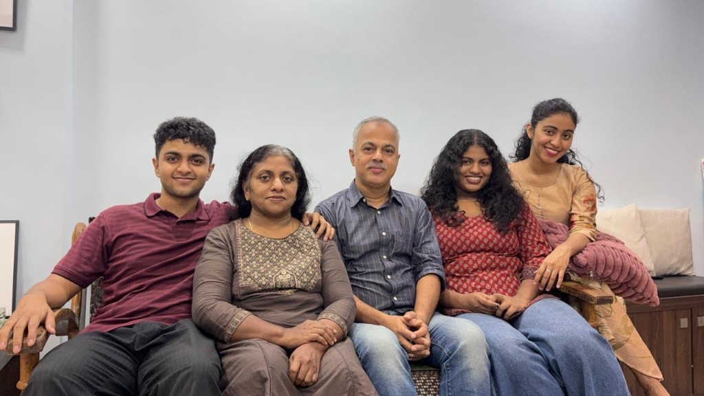A family of five sitting together on a sofa