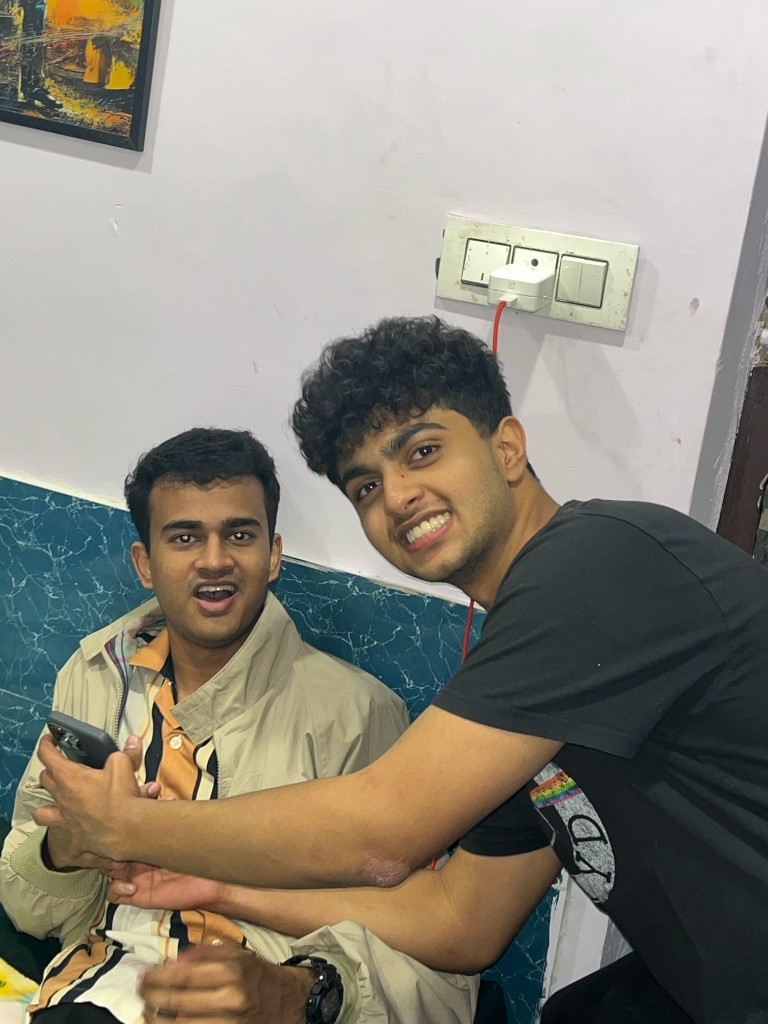 Two friends sitting together against a painted wall